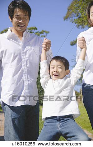 Stock Photograph - Parents lifting son. Fotosearch