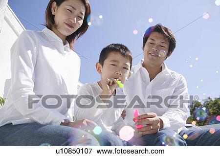Son playing with bubbles and parents watching View Large Photo Image Stock Photo - Son playing with bubbles and parents watching. Fotosearch