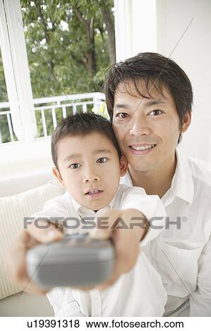 Son pointing with remote control View Large Photo Image Stock Photo - Son pointing with remote control. Fotosearch