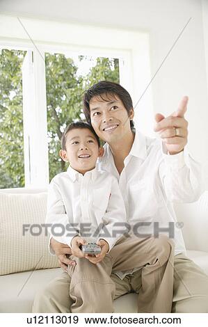 Son sitting on father's lap View Large Photo Image Stock Photo - Son sitting on father's lap. Fotosearch