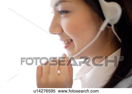 Close-up of young woman wearing headset View Large Photo Image Stock Photography - Close-up of young woman wearing headset. Fotosearch