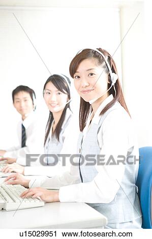 Stock Image - Three young adults wearing headsets. Fotosearch