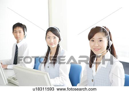 Stock Image - Three young adults wearing headsets. Fotosearch