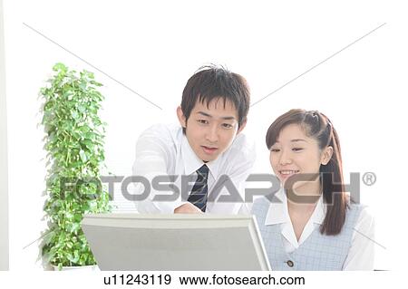 Two young adults working on computer View Large Photo Image Stock Photo - Two young adults working on computer. Fotosearch
