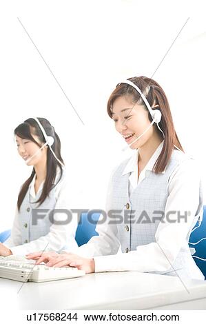 Picture - Two young women wearing headsets. Fotosearch