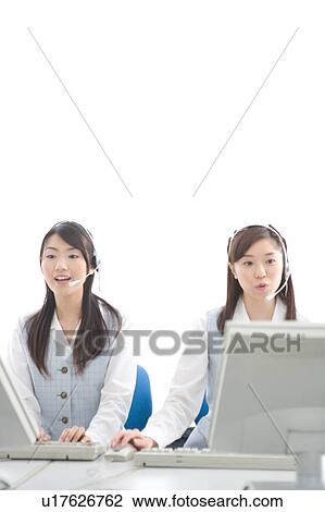 Two young women wearing headsets View Large Photo Image Stock Image - Two young women wearing headsets. Fotosearch