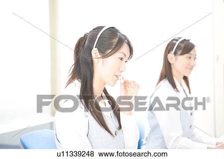 Stock Photo - Two young women wearing headsets. Fotosearch