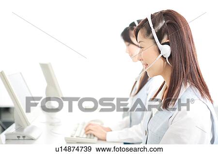 Two young women wearing headsets View Large Photo Image Stock Photo - Two young women wearing headsets. Fotosearch