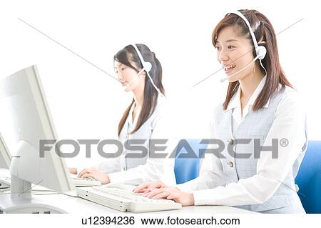 Stock Photograph - Two young women wearing headsets. Fotosearch