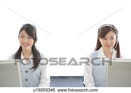 Two young women wearing headsets View Large Photo Image Stock Photograph - Two young women wearing headsets. Fotosearch