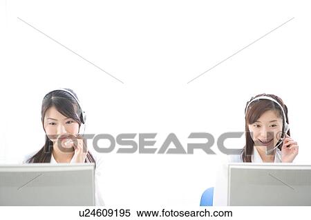 Stock Photography - Two young women wearing headsets. Fotosearch