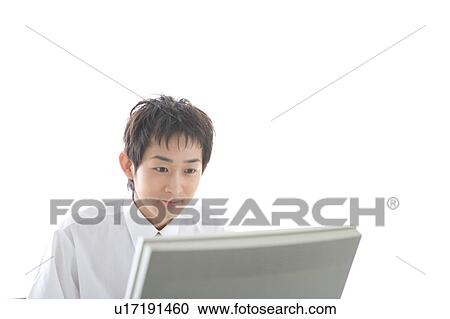 Stock Image - Young man working on computer. Fotosearch