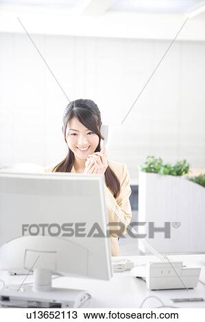 Stock Image - Young woman talking on phone. Fotosearch