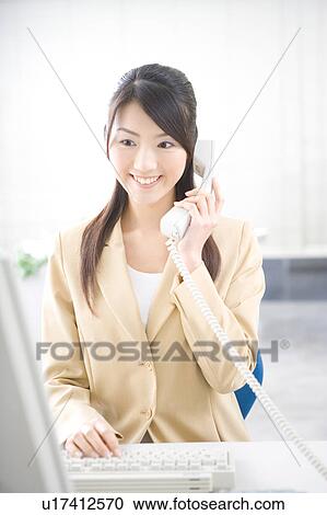 Stock Image - Young woman talking on phone. Fotosearch