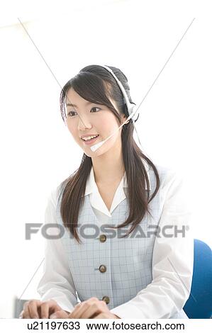 Stock Image - Young woman wearing headset. Fotosearch