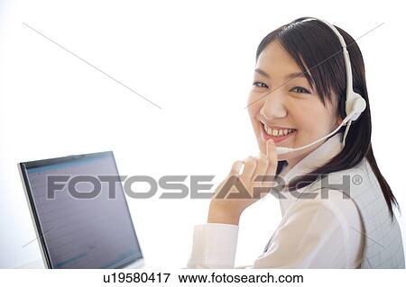 Stock Photo - Young woman wearing headset. Fotosearch