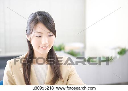 Young woman working in office View Large Photo Image Stock Photo - Young woman working in office. Fotosearch