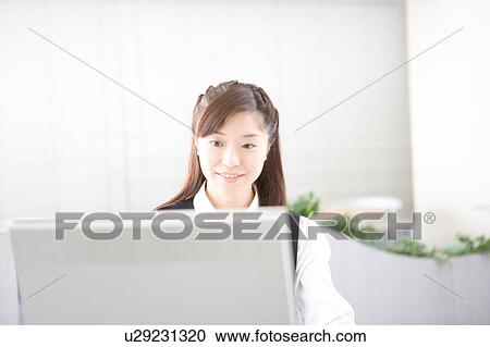 Young woman working on computer View Large Photo Image Stock Image - Young woman working on computer. Fotosearch