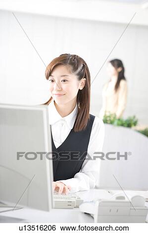 Stock Photograph - Young woman working on computer. Fotosearch