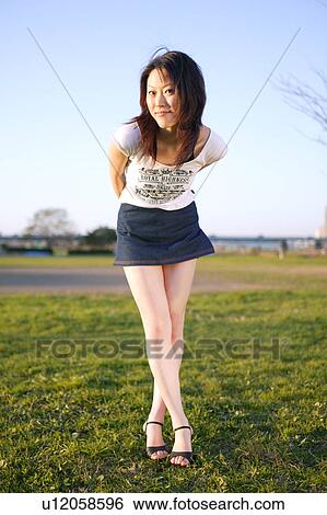 Portrait of young woman standing in field View Large Photo Image Stock Photograph - Portrait of young woman standing in field. Fotosearch