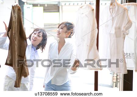 Two young women shopping at clothing store View Large Photo Image Stock Photo - Two young women shopping at clothing store. Fotosearch