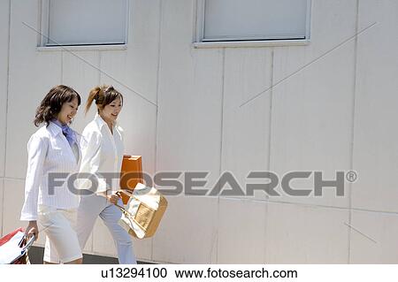 Stock Image - Two young women walking. Fotosearch