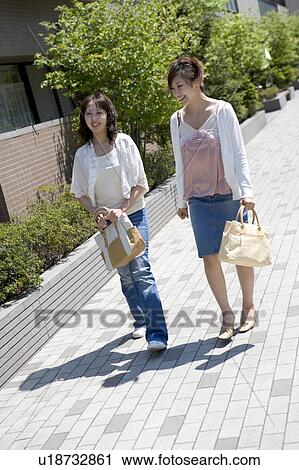 Stock Image - Two young women walking. Fotosearch