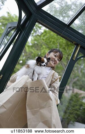 Young woman holding dog View Large Photo Image Stock Photo - Young woman holding dog. Fotosearch