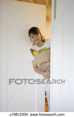 Picture - Young woman holding grocery bag. Fotosearch