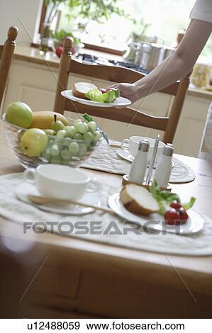 Stock Photo - Young woman setting table. Fotosearch