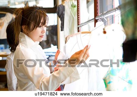 Young woman shopping at clothing store View Large Photo Image Picture - Young woman shopping at clothing store. Fotosearch