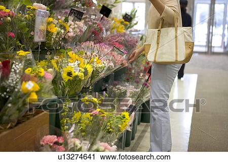 Stock Image - Young woman shopping at florist. Fotosearch
