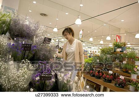 Stock Image - Young woman shopping at florist. Fotosearch
