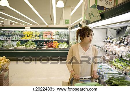 Stock Photography - Young woman shopping at supermarket. Fotosearch