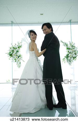Stock Image - Bride and groom at altar. Fotosearch