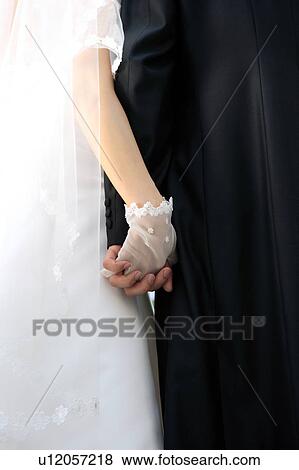 Stock Photo - Bride and groom holding hands. Fotosearch