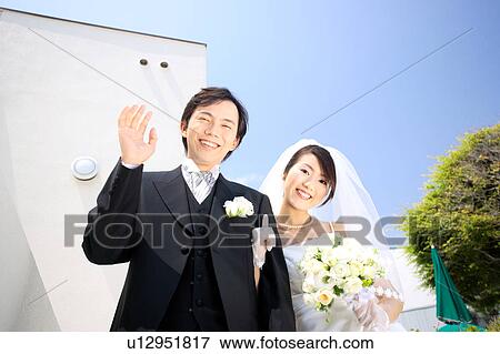 Stock Photo - Bride and groom looking at camera. Fotosearch