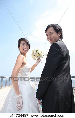 Bride and groom looking at camera View Large Photo Image Stock Photo - Bride and groom looking at camera. Fotosearch
