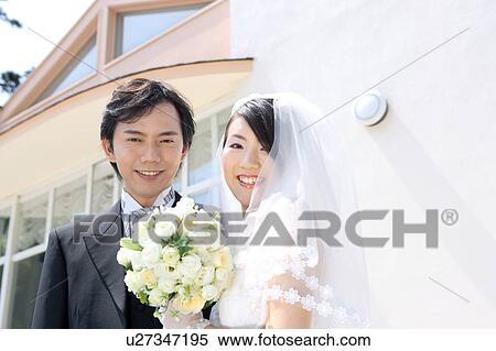 Stock Photography - Bride and groom looking at camera. Fotosearch