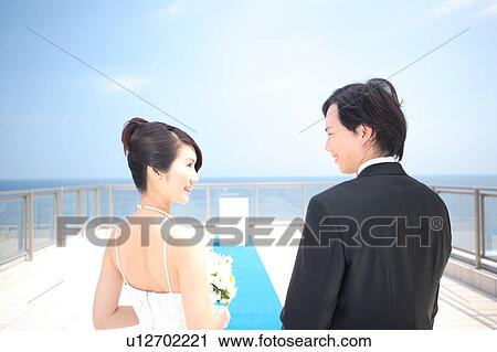 Stock Image - Bride and groom looking at each other. Fotosearch