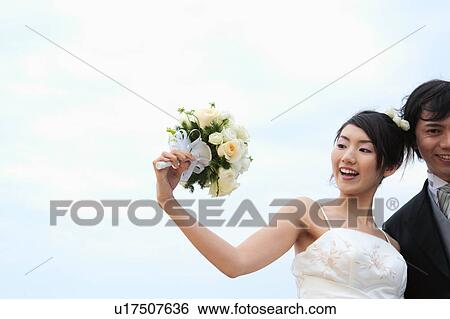Stock Photograph - Bride and groom with flowers. Fotosearch