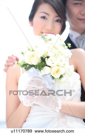 Stock Photo - Bride holding bouquet of flowers. Fotosearch