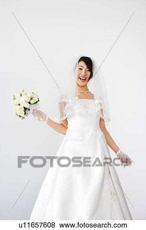 Bride holding bouquet of flowers View Large Photo Image Stock Photo - Bride holding bouquet of flowers. Fotosearch
