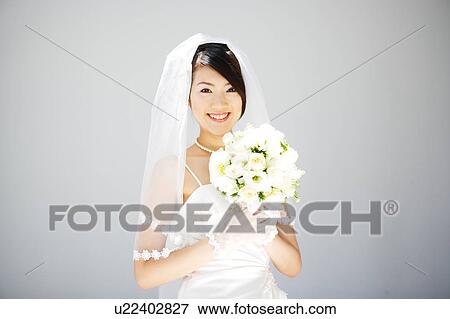 Bride holding bouquet of flowers View Large Photo Image Stock Photo - Bride holding bouquet of flowers. Fotosearch