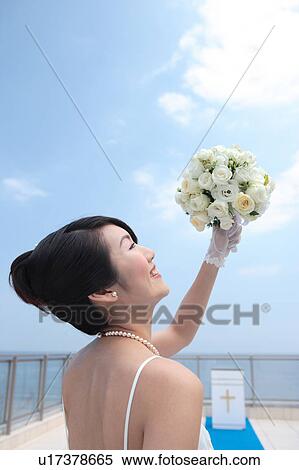Bride holding up bouquet of flowers View Large Photo Image Stock Photography - Bride holding up bouquet of flowers. Fotosearch