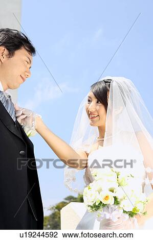 Bride straightening groom's tie View Large Photo Image Stock Image - Bride straightening groom's tie. Fotosearch