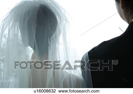 Stock Image - Rear view of bride and groom at altar. Fotosearch