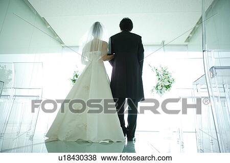 Stock Photo - Rear view of bride and groom at altar. Fotosearch