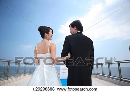 Rear view of bride and groom looking at each other View Large Photo Image Stock Photo - Rear view of bride and groom looking at each other. Fotosearch