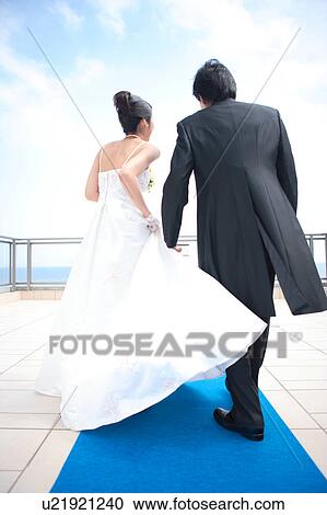 Rear view of bride and groom walking View Large Photo Image Stock Image - Rear view of bride and groom walking. Fotosearch